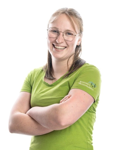 Frau mit verschränkten Armen, grünem Shirt.